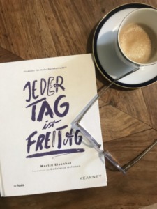 Das Buch "Jeden Tag ist Freitag" liegt geschlossen auf einem Coffee Table.