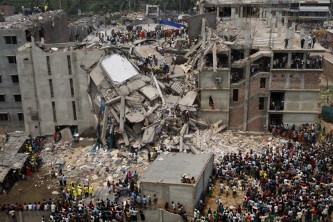 Auf dem Bild sehen wir das eingestürzte Fabrikgebäude Rana Plaza zwischen anderen Gebäuden und hunderten von Menschen