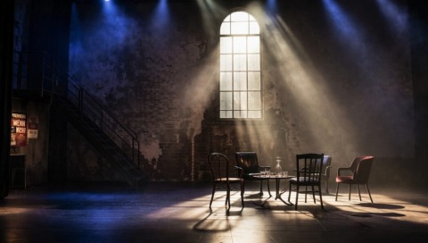 Ein dunkle Bühnen mit Stuhlkreis.