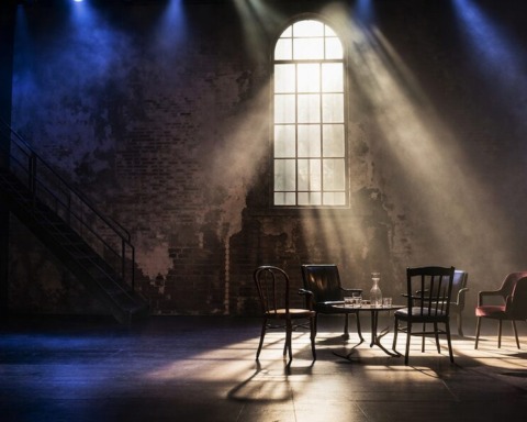 Ein dunkle Bühnen mit Stuhlkreis.