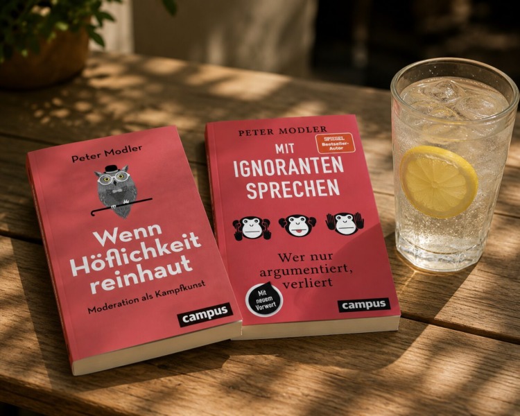 Zwei rote Bücher liegen auf einem Tisch. Daneben ein Wasserglas mit Eiswürfel und einer Scheibe Zitrone. Beide Bücher sind von demselben Autor Peter Modler. Das Buch links hat den Titel "Wenn Höflichkeit reinhaut" und das Buch rechts daneben "Mit Ignoranten sprechen".